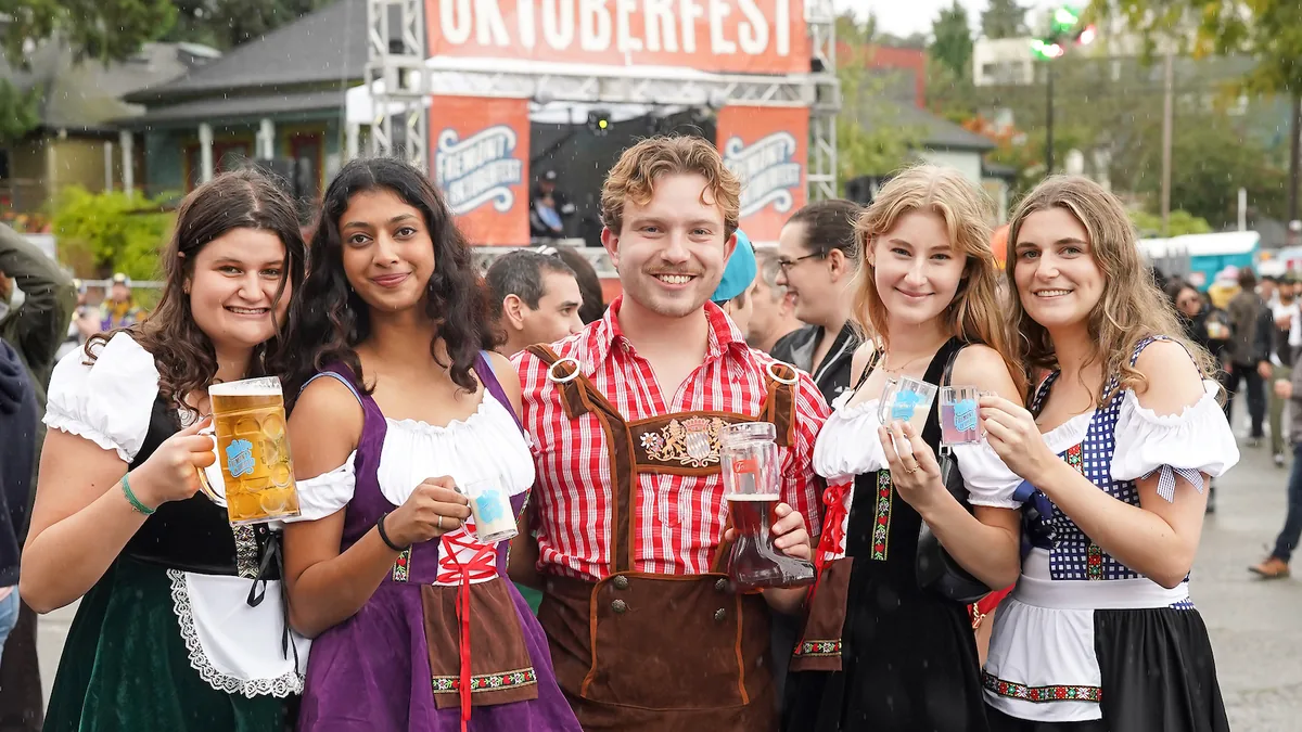 Festivalgoers in traditional Bavarian-style clothing at Fremont Oktoberfest in Seattle.